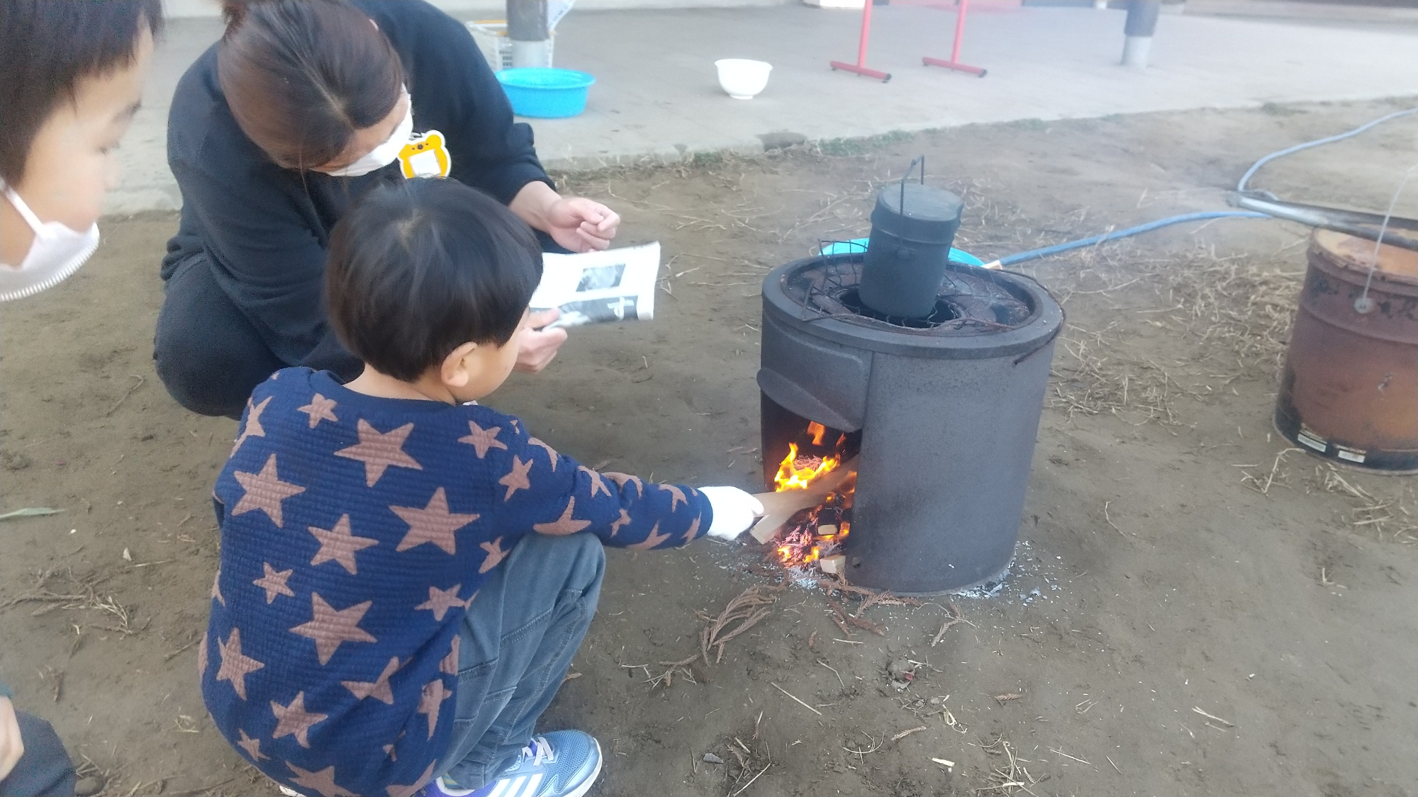 火に薪をくべる子ども