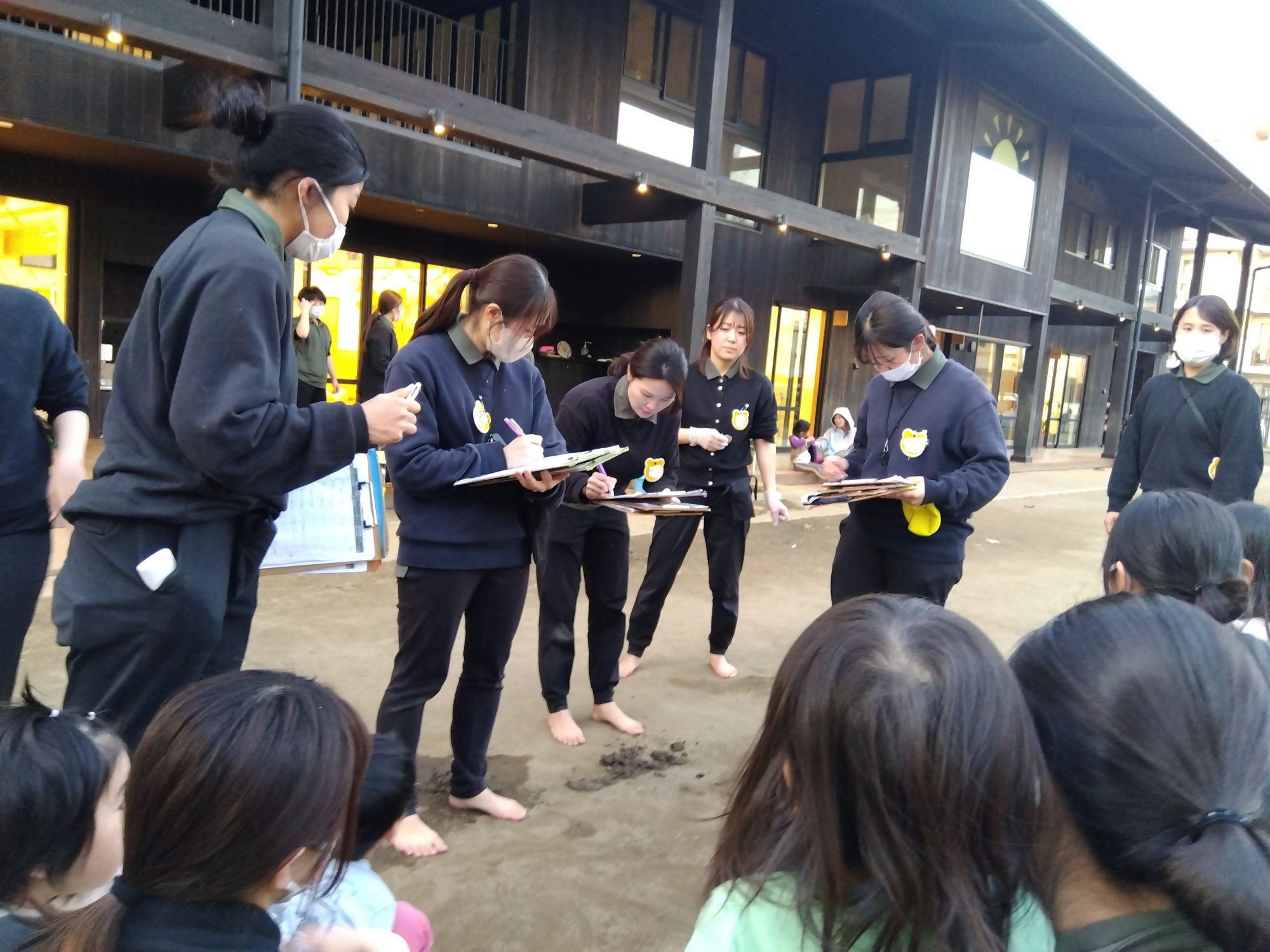 園庭に避難し、リーダーに報告するスタッフ