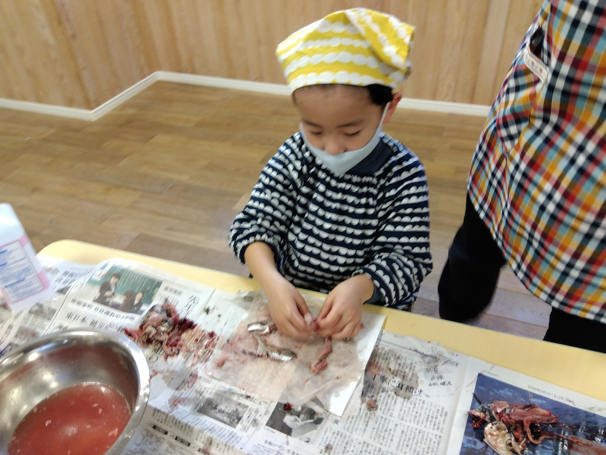 魚を手でさばく子ども