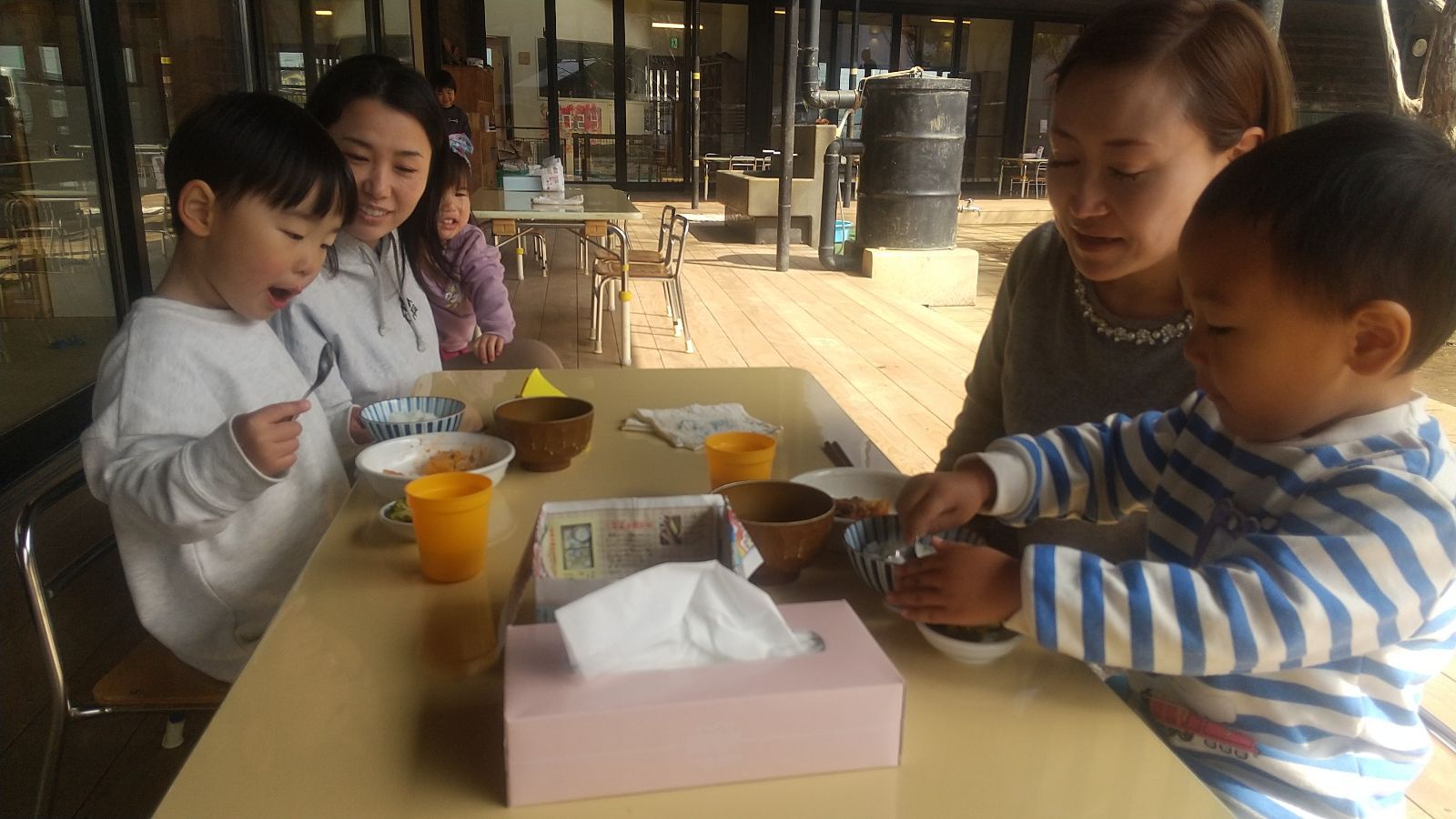 給食を食べる子どもたちと見守る保護者