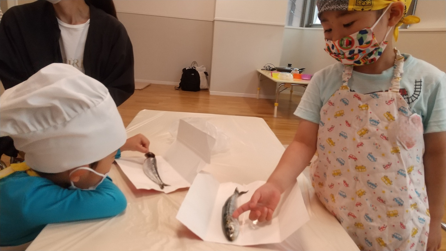 イワシに触れてみる子どもたち