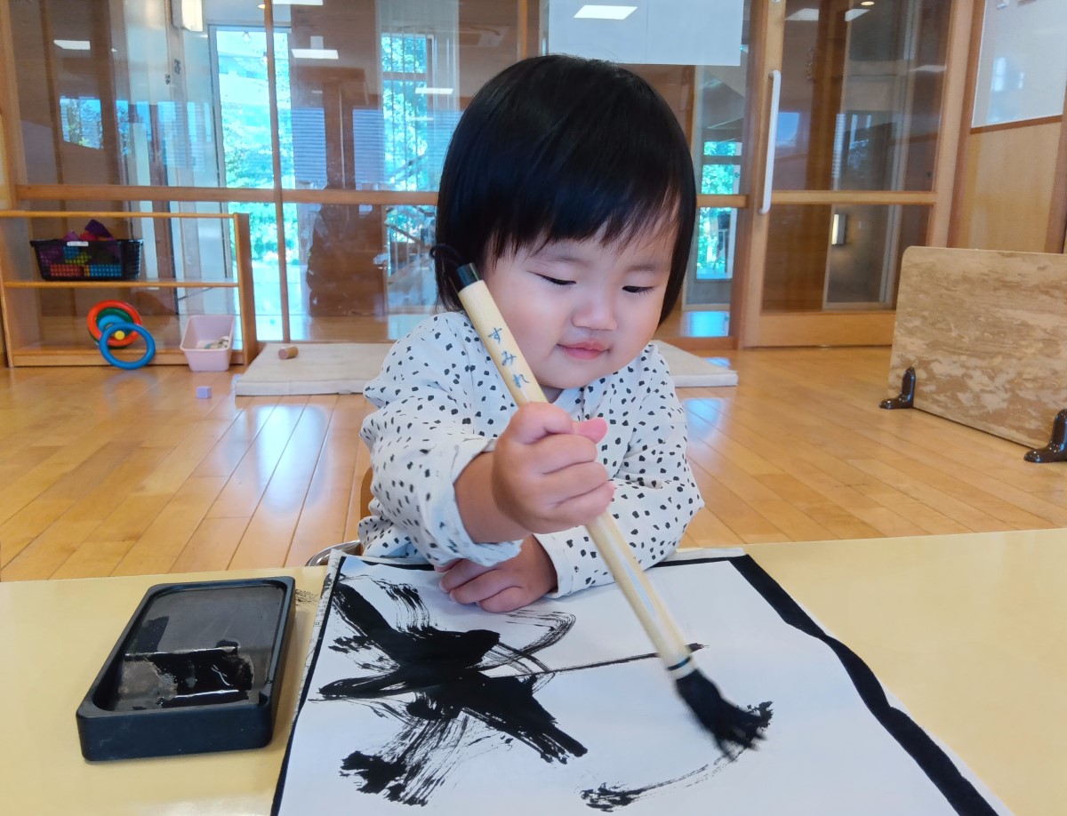 筆を使って半紙に描く子ども