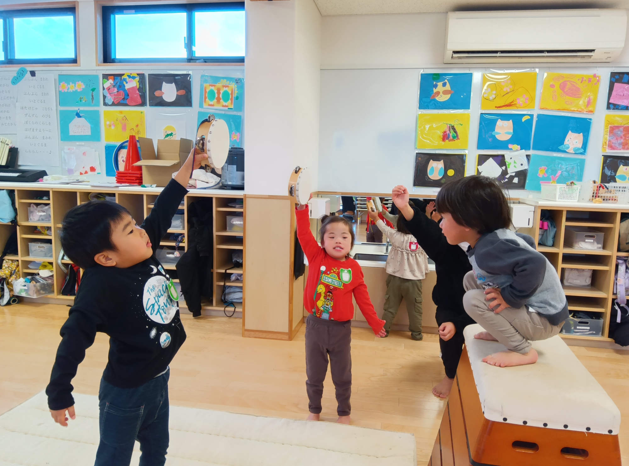 タンバリンを掲げる子どもたち