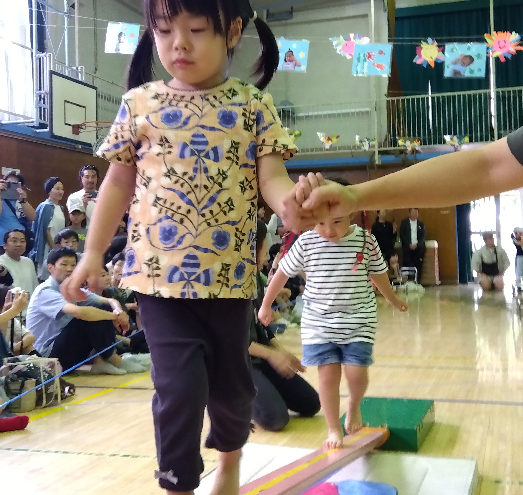 スタッフと手をつないで歩く子ども