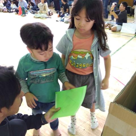 緑の紙を持つ子ども