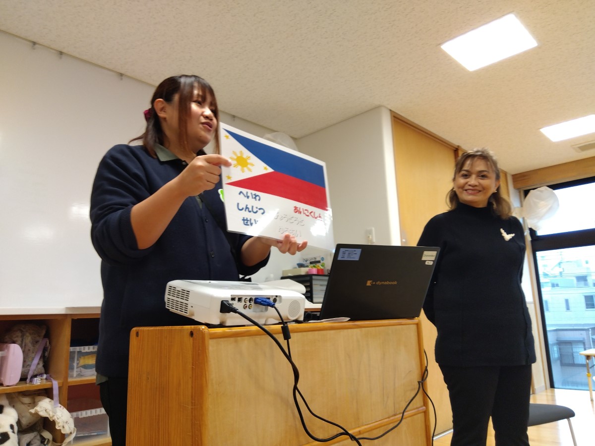 子どもたちにフィリピンの国旗を見せる