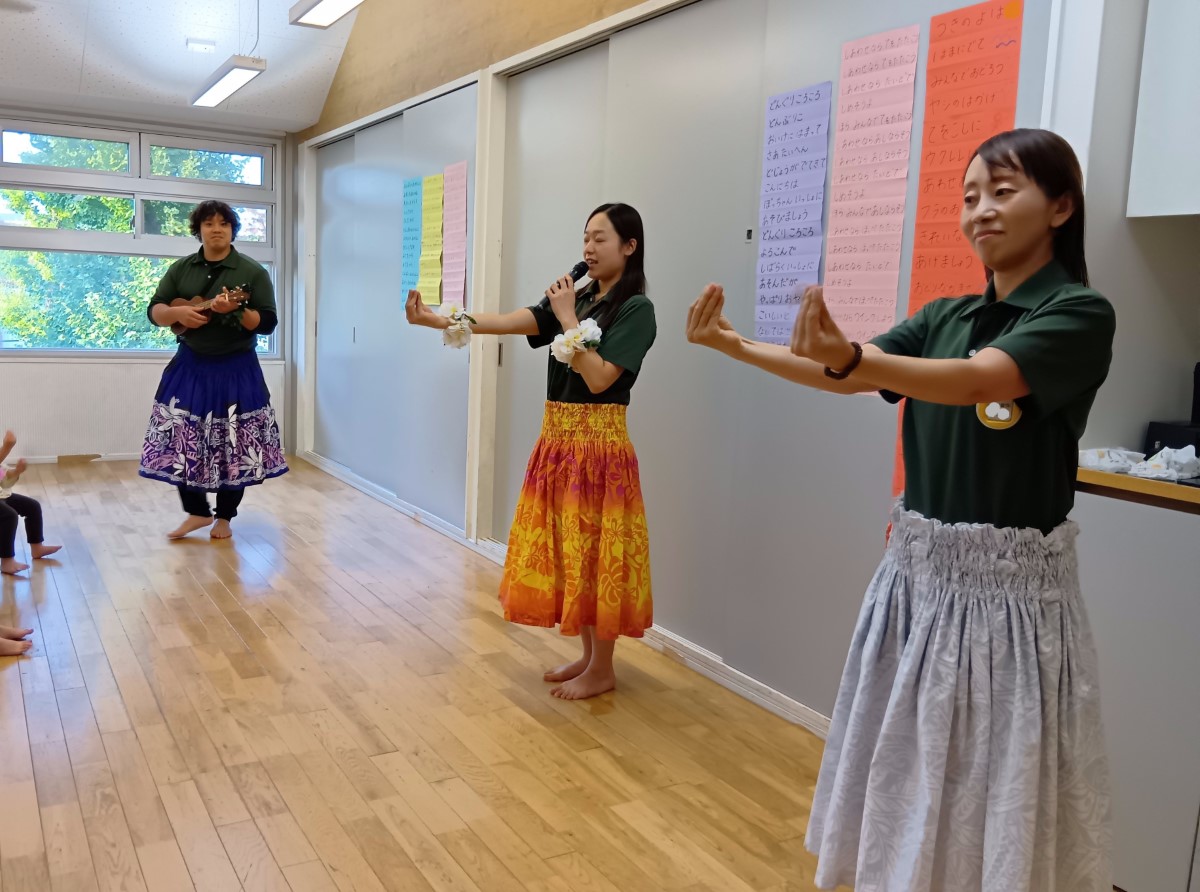 フラダンスを実際に踊ってみせるスタッフ