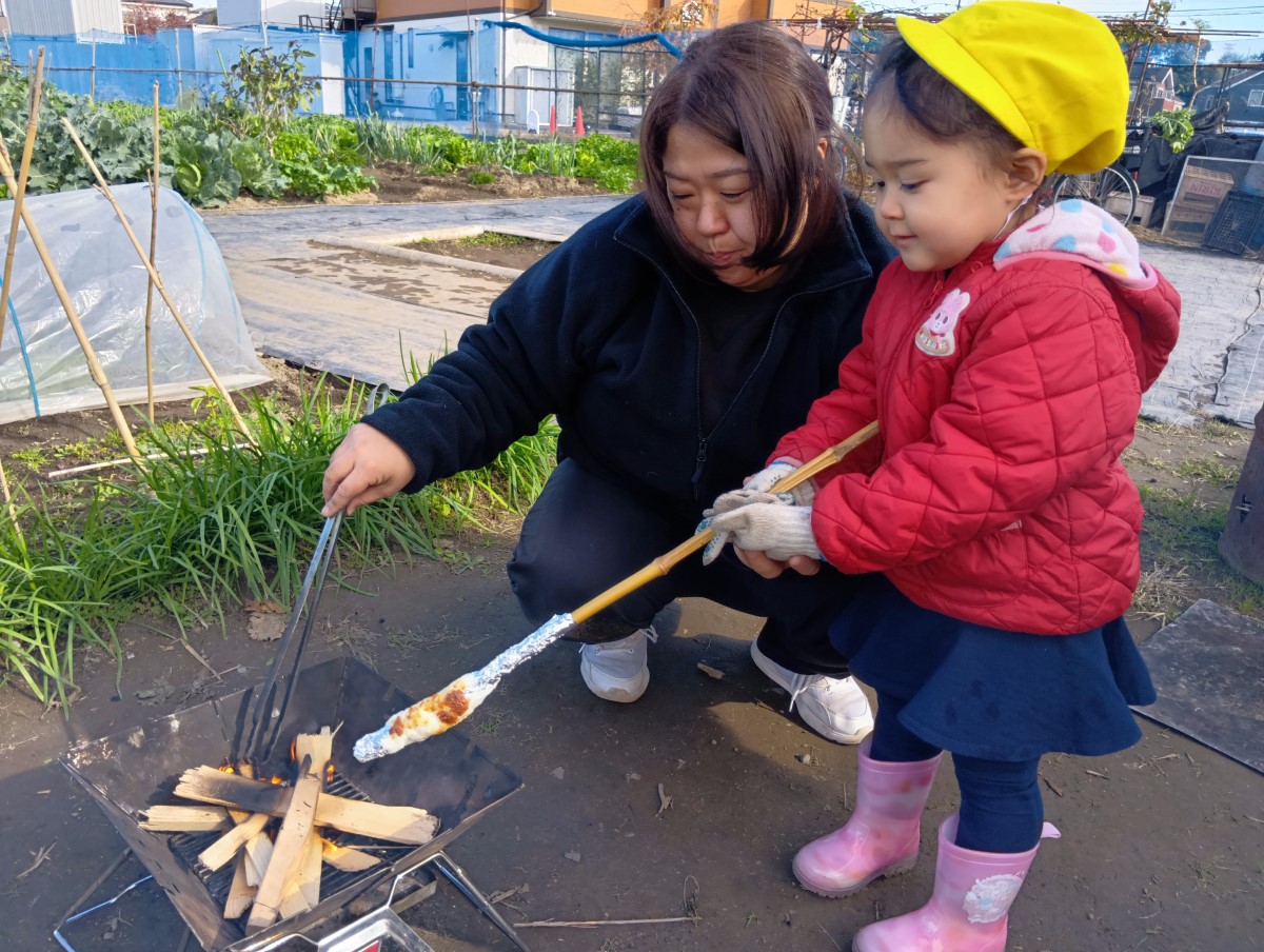 味噌たんぽを火に近づける子ども