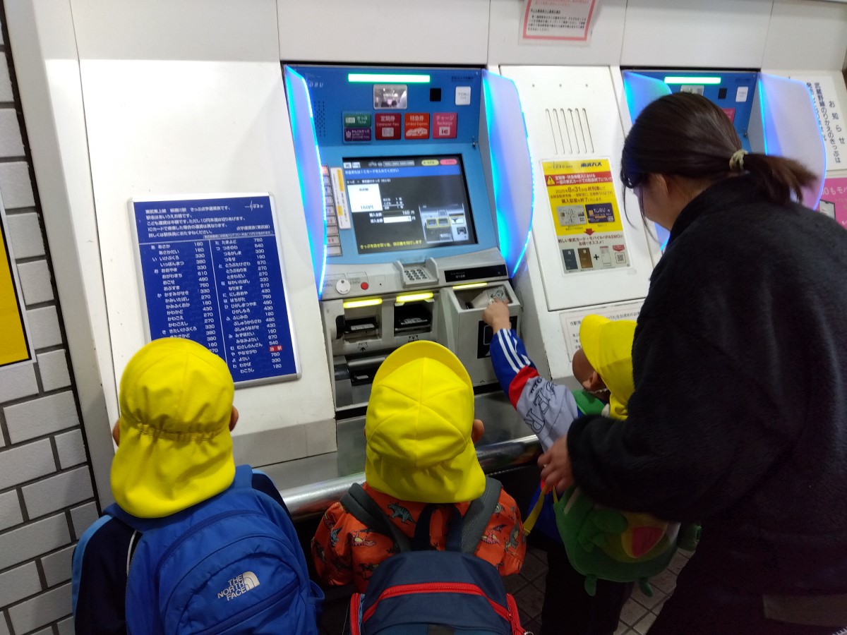 券売機で切符を買う子どもたち