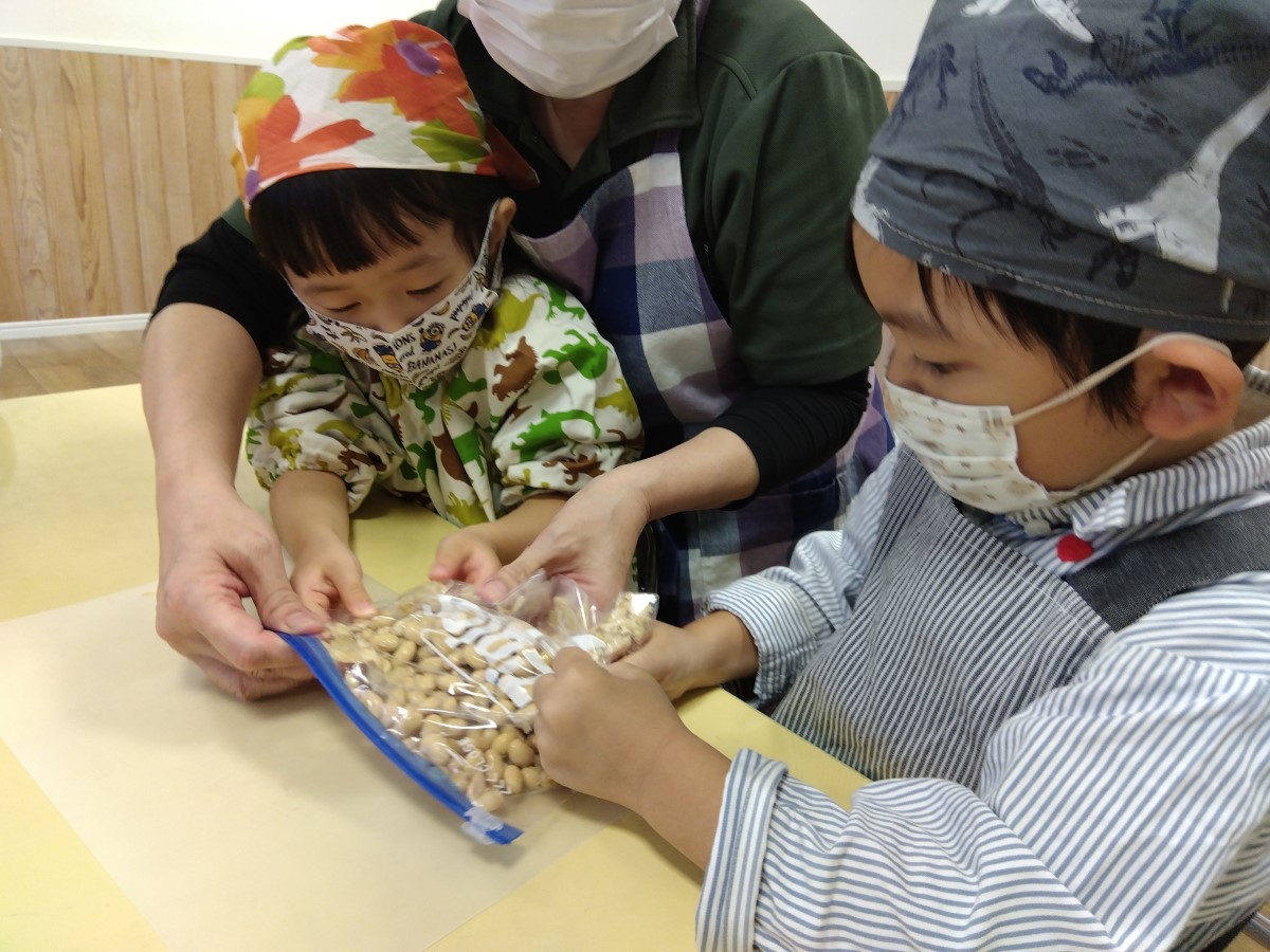 大豆を袋の上から潰す子どもたち