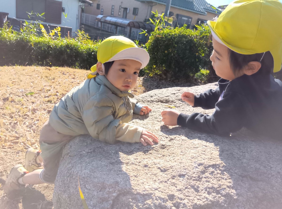 大きな石に登る子どもたち