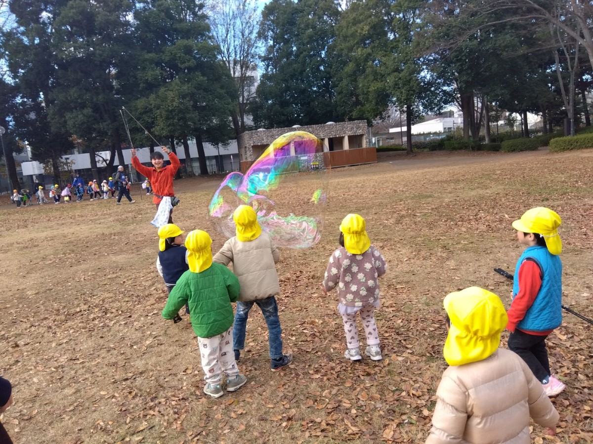 公園で大きなシャボン玉を作る子どもたち