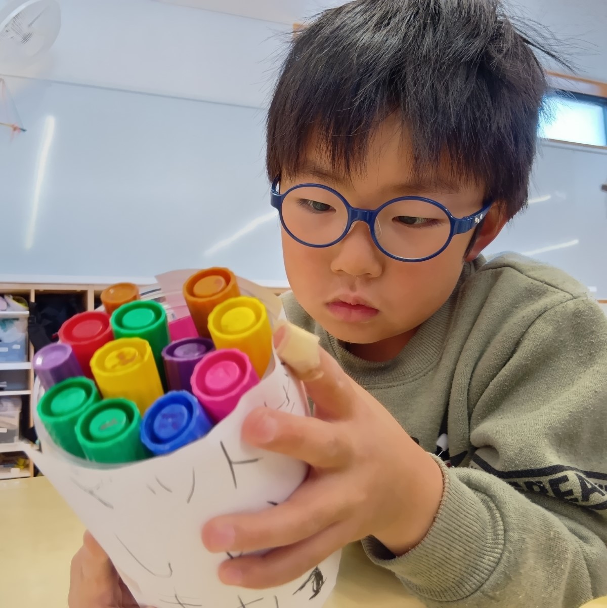 ペン立てを眺める子ども