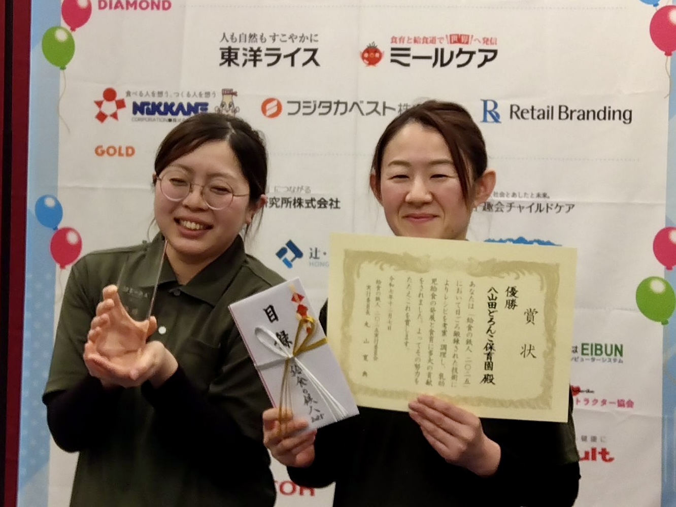 賞状とトロフィーを手にする参加した調理スタッフの佐藤さんと滝田さん