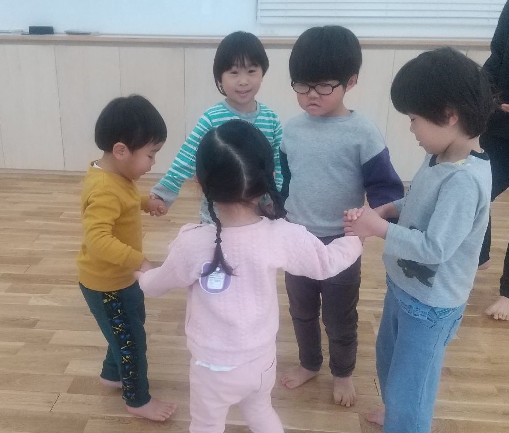 手をつなぎ輪になる子どもたち