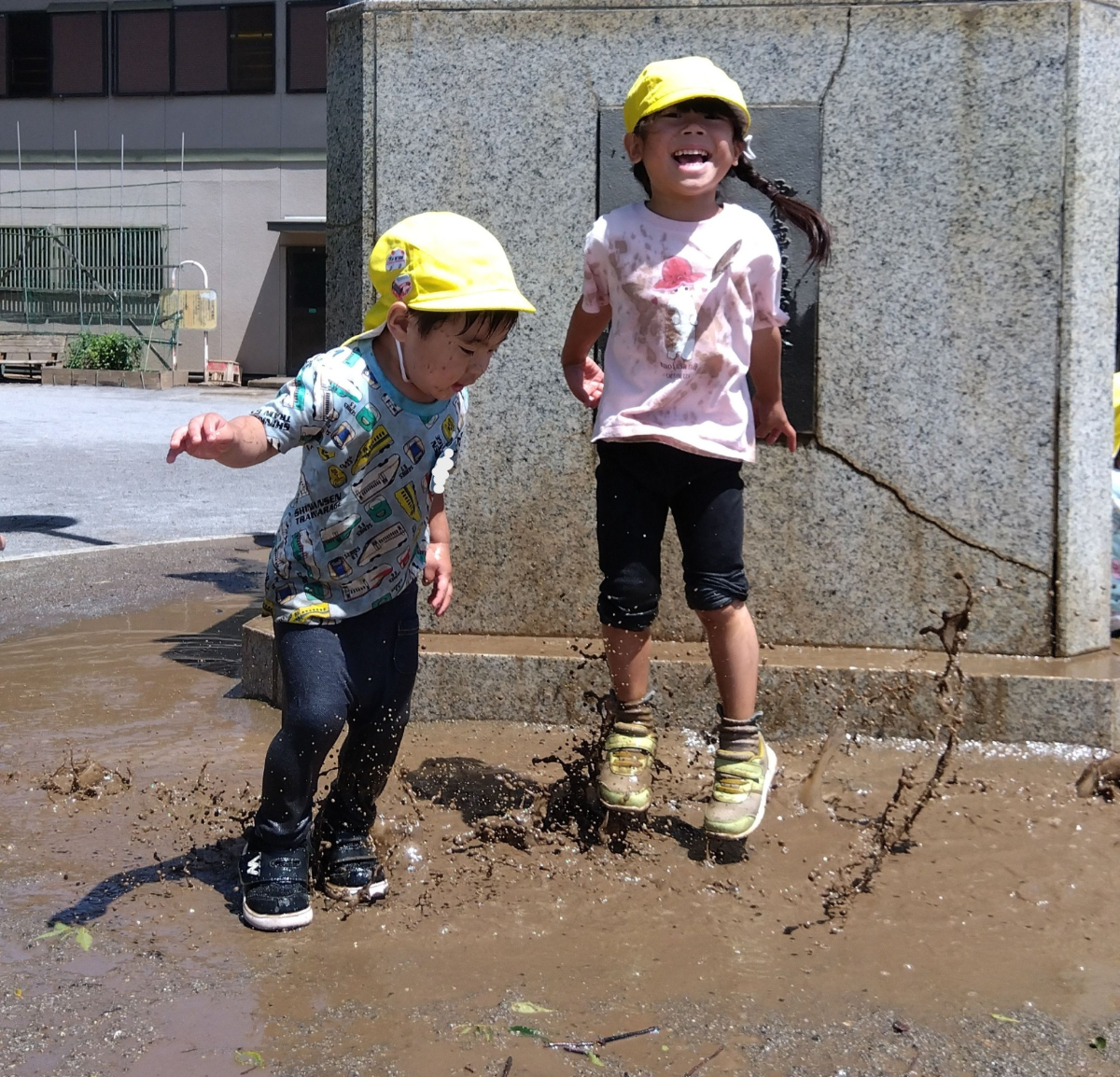 水たまりで遊ぶ子どもたち