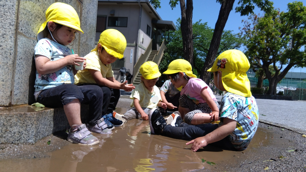 みんなで水たまりで遊ぶ様子