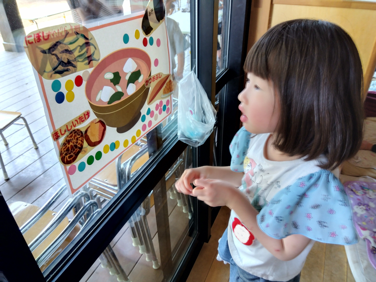 だし汁の貼り紙を見る子ども