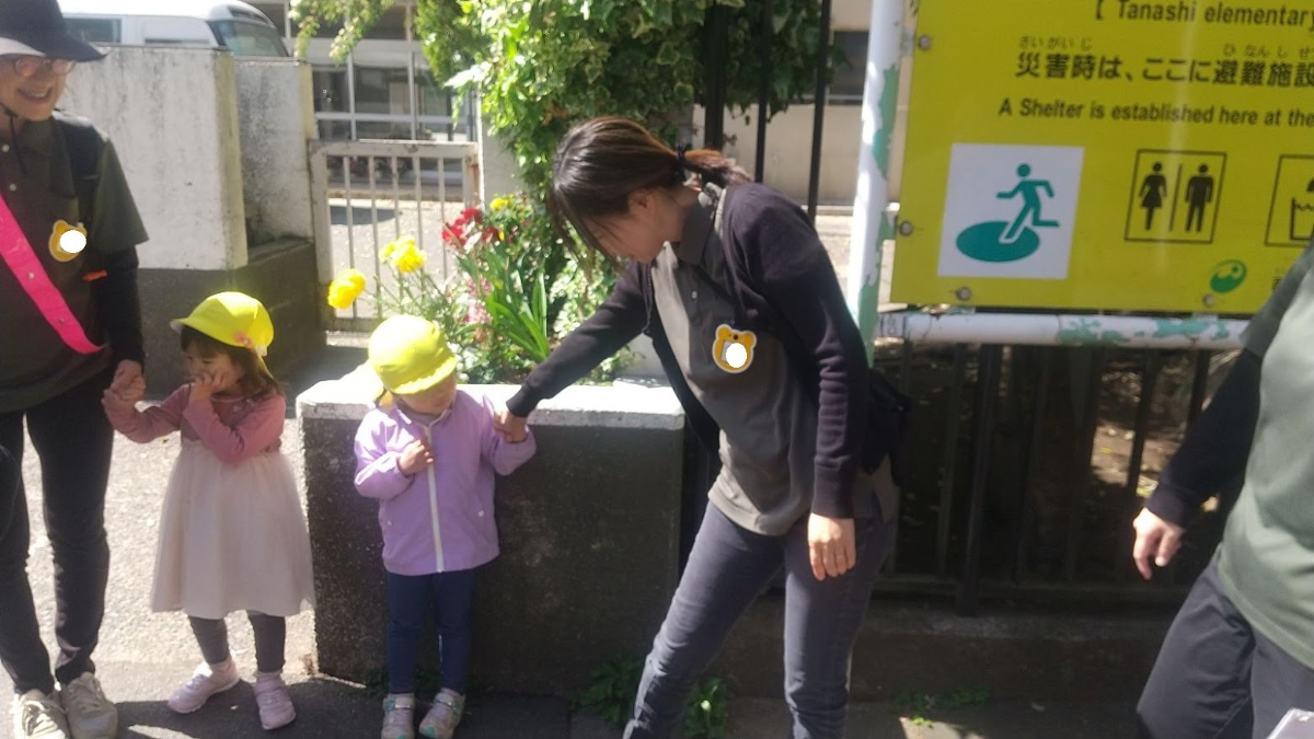 保育者と手をつなぐ子どもたち