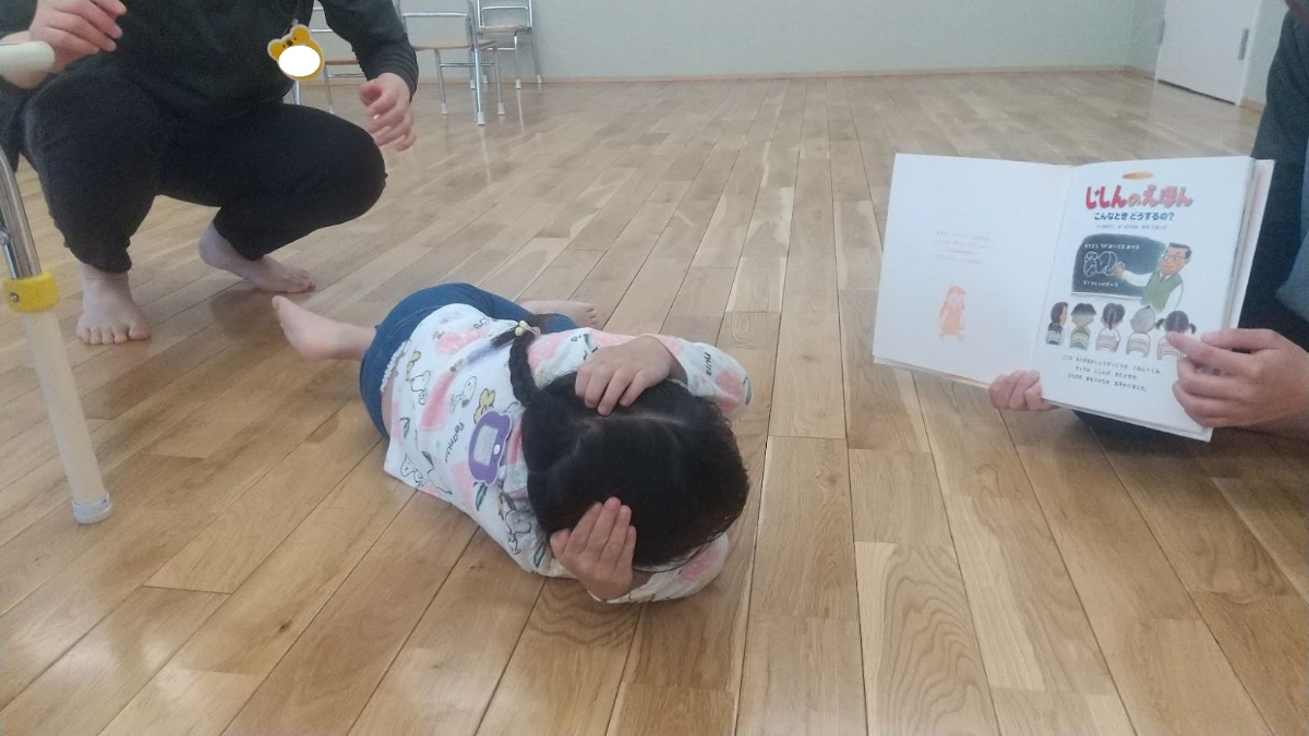 頭を守るポーズをとる子ども