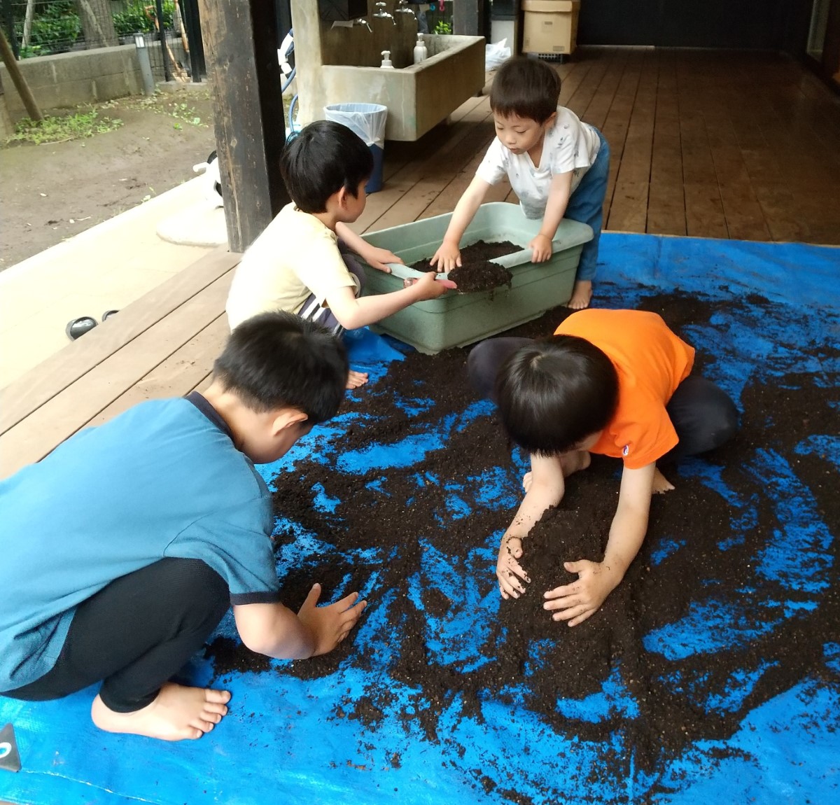プランターに土を入れる子どもたち