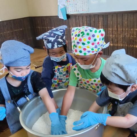 潰した大豆を鍋で混ぜる子どもたち