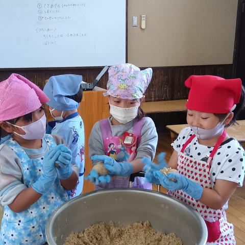 混ざった大豆を手で丸める子どもたち