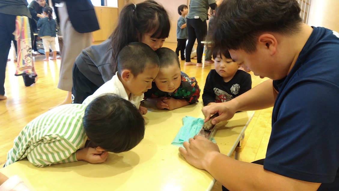 かつお節を削る様子を眺める子どもたち