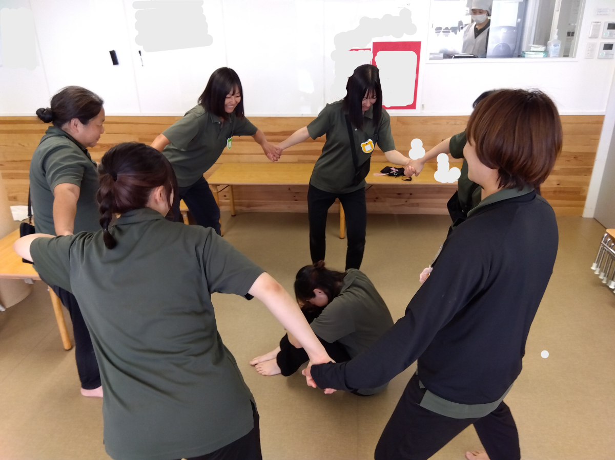 スタッフ同士で伝承遊びをやってみる様子