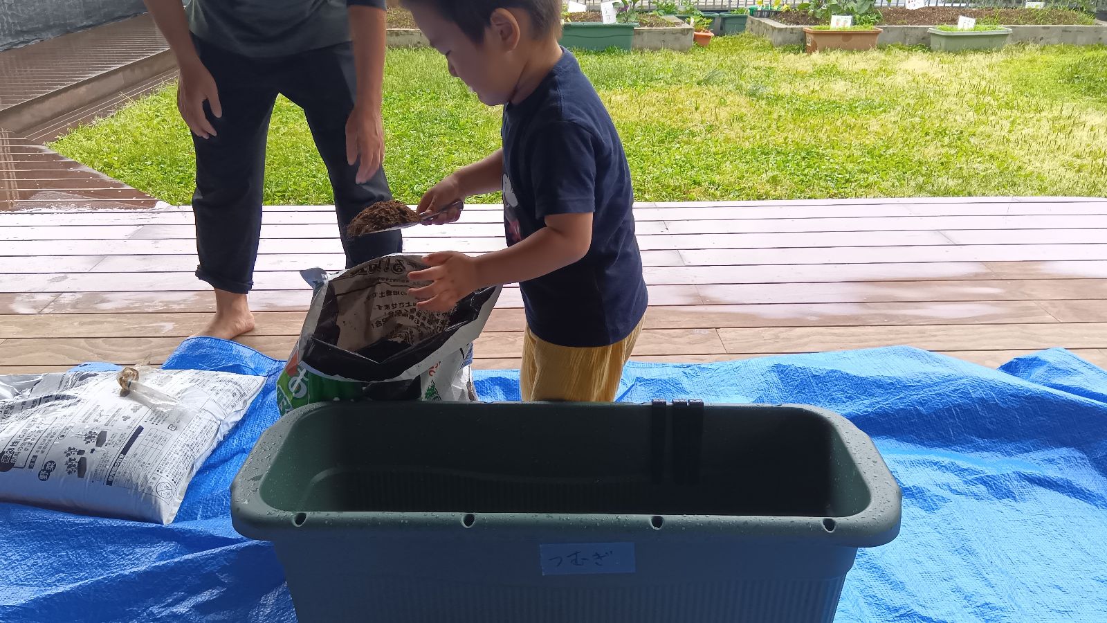 プランターに土を移し替える子ども