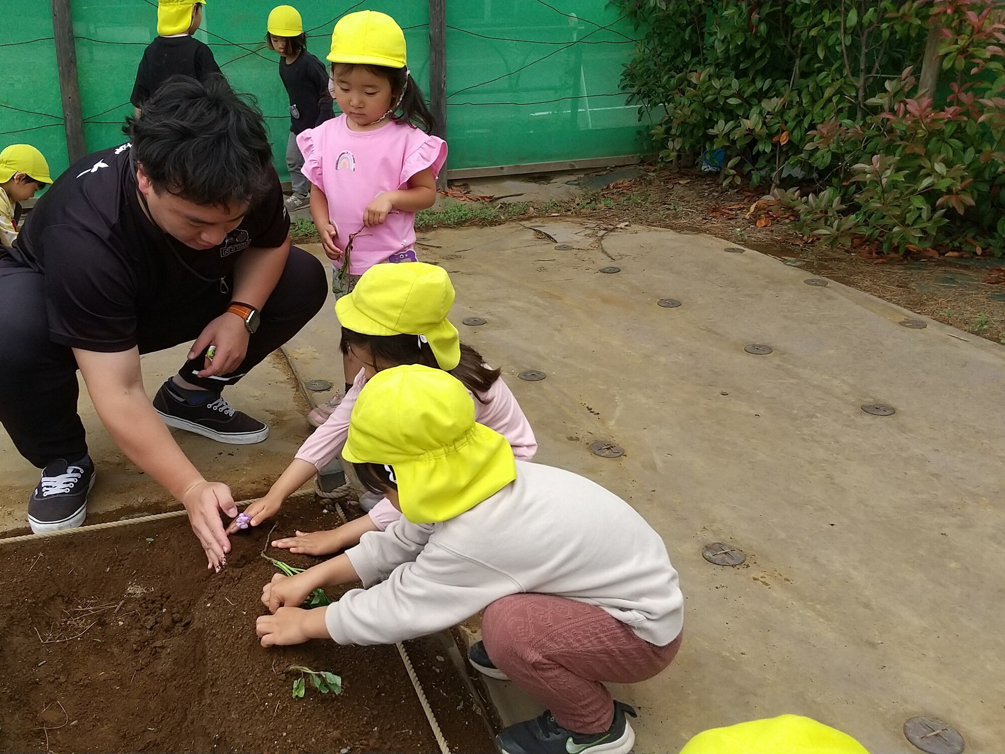 子どもたちと一緒に畑仕事をする研修生の荘さん