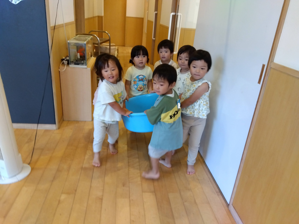 たらいをみんなで協力して運ぶ