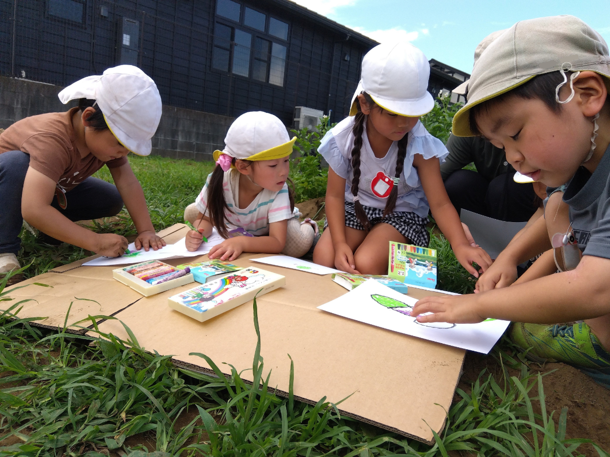 屋外でスケッチをする子どもたち