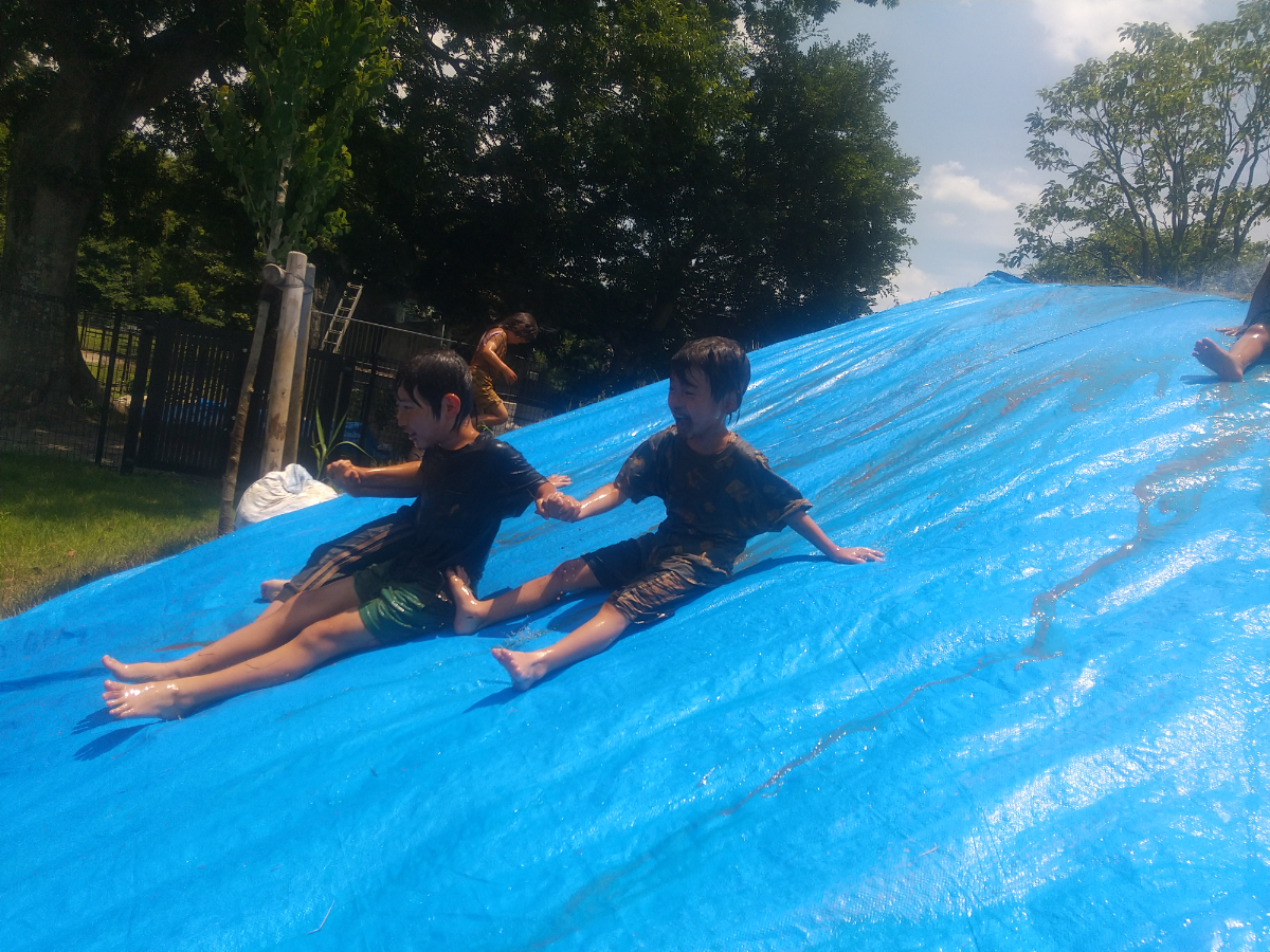 どろんこスライダーを楽しむ子どもたち