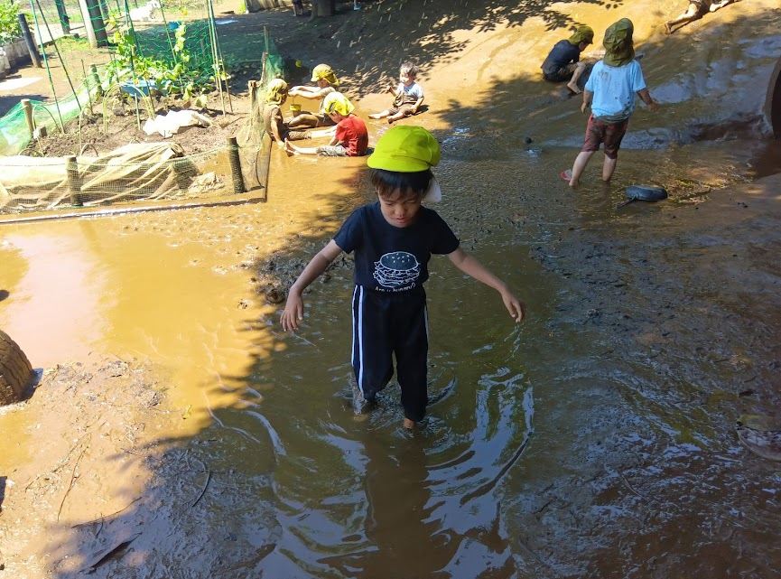 泥の中を歩く子ども