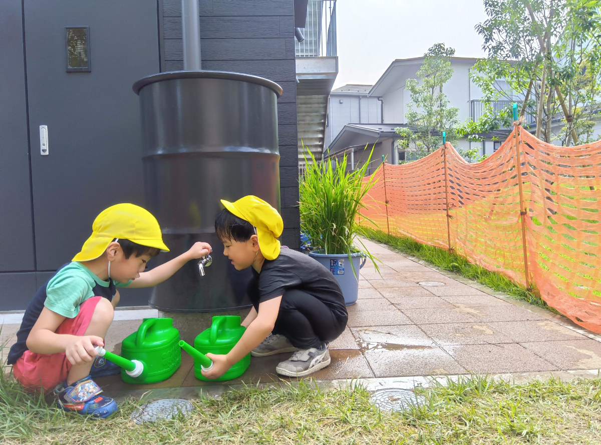 じょうろに水を入れる子どもたち