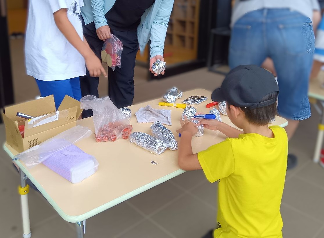 野菜をアルミホイルで包む子ども