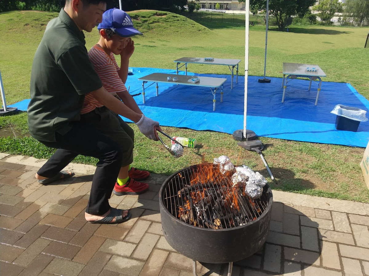 包んだ野菜を網の上に置く子ども