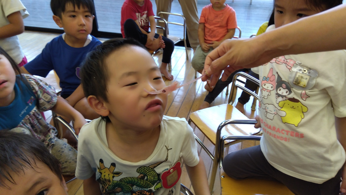 まぐろの中骨を嗅ぐ子ども