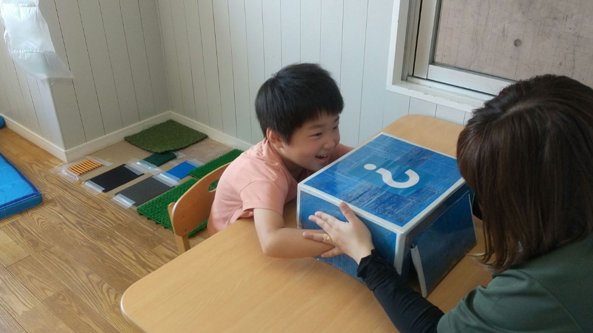 箱の中身を当てるゲームをする子ども