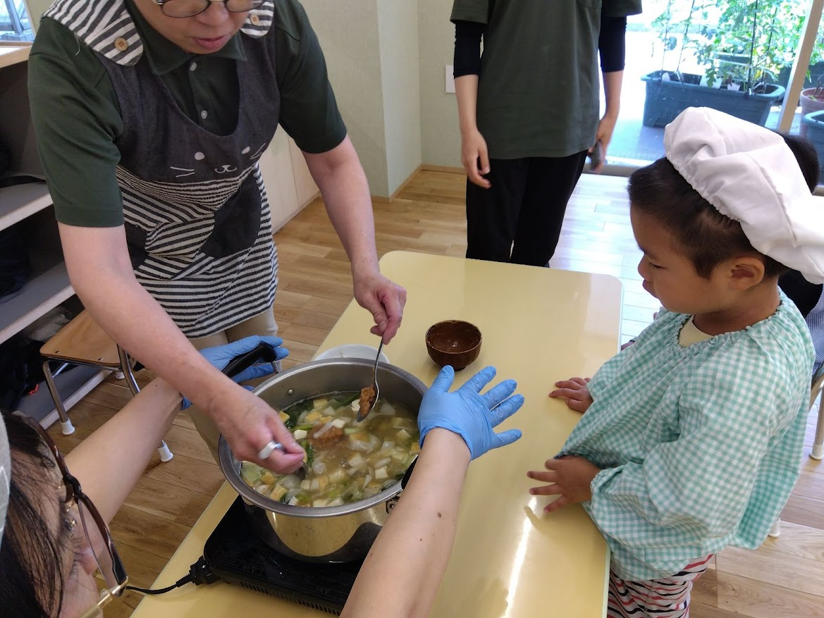 味噌を溶く様子を見つめる子ども