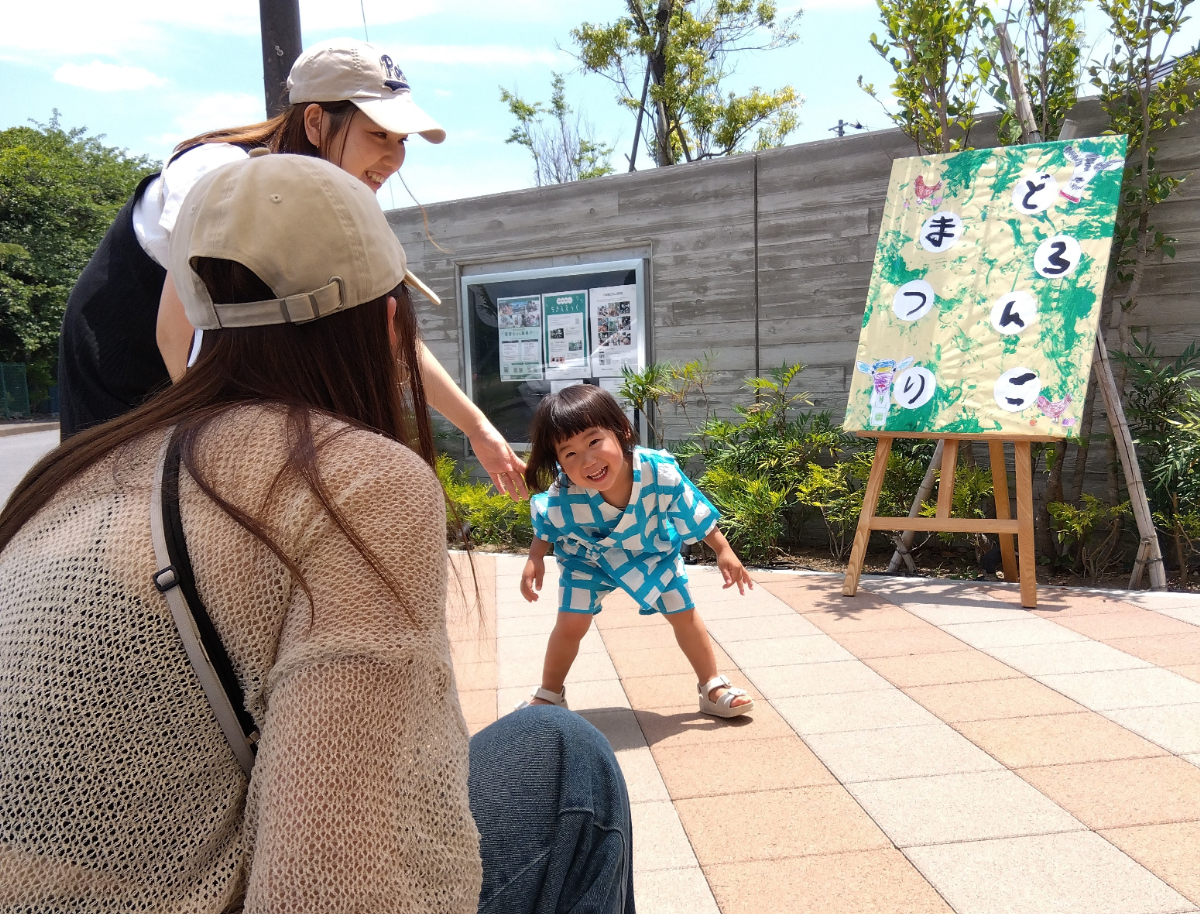 どろんこまつりの看板と笑顔の子ども