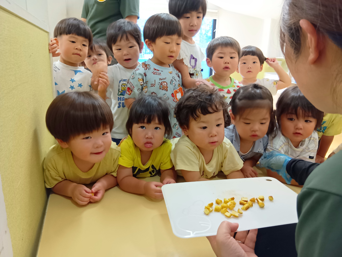 焼かれたヤングコーンを見る子どもたち