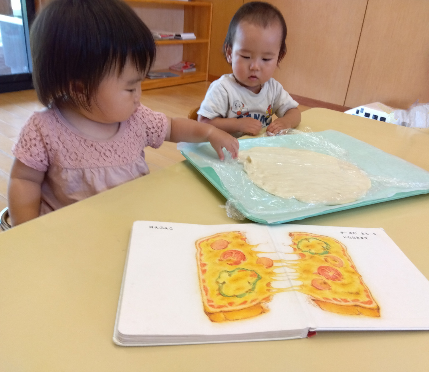 ピザ生地に触れてみる子どもたち