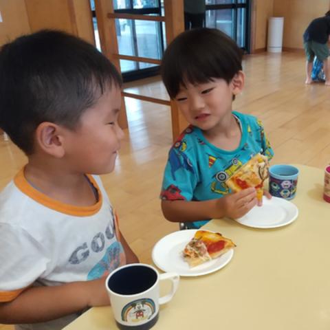 焼き上がったピザを食べる子どもたち