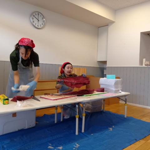 マグロの切り身を子どもたちに見せるスタッフ