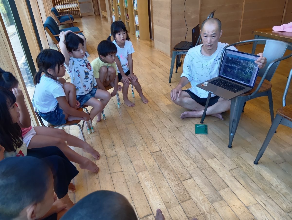 パソコンで画面を見せながら子どもたちに話す様子