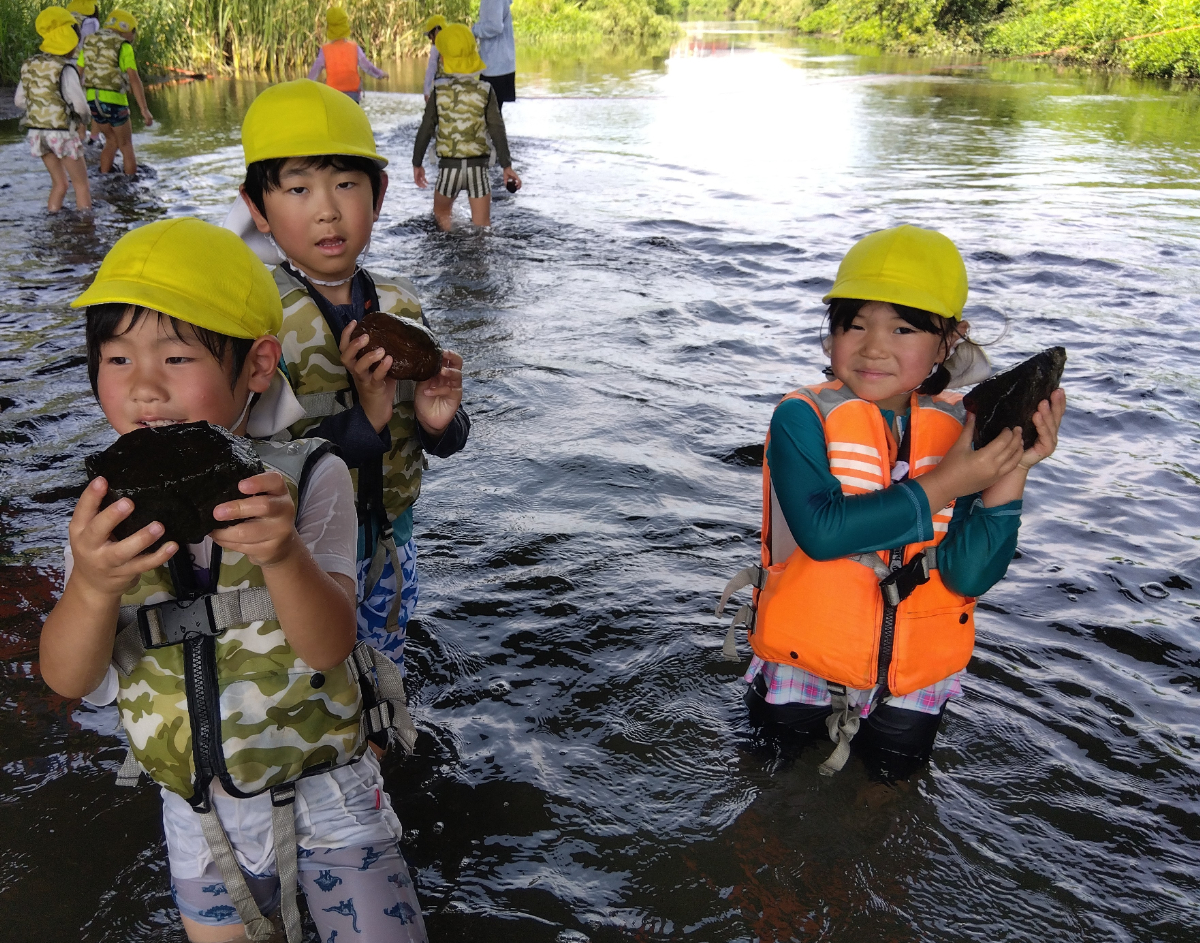 川の石を拾う子どもたち