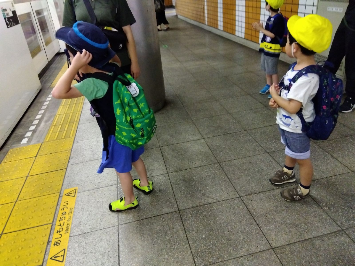 駅のホームで電車を待つ子どもたち