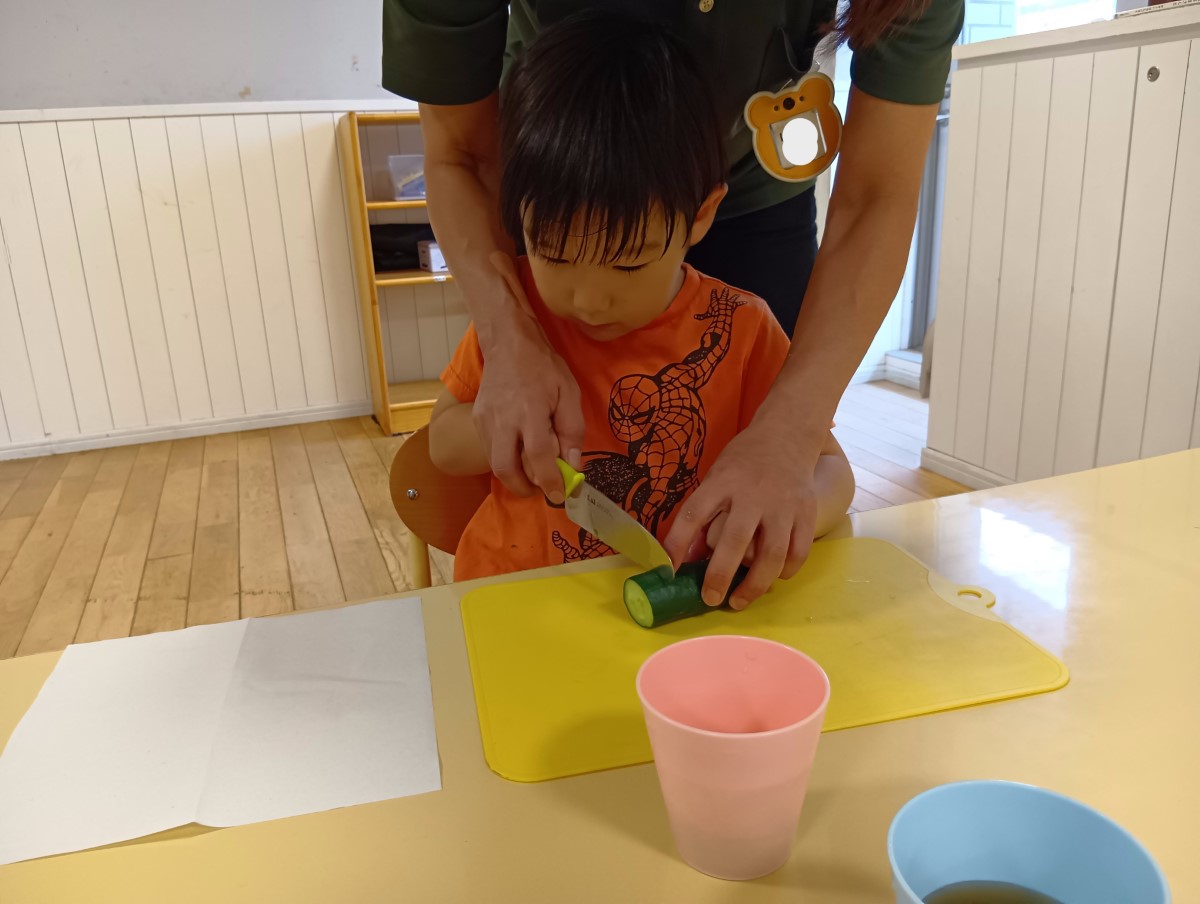 包丁できゅうりを切る子ども
